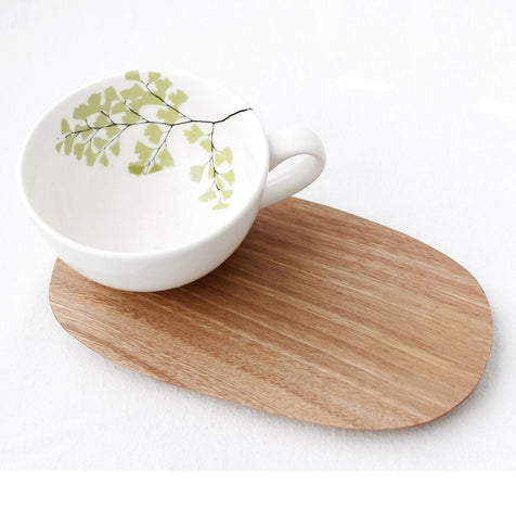 White cappuccino cup with fern design and wooden saucer 