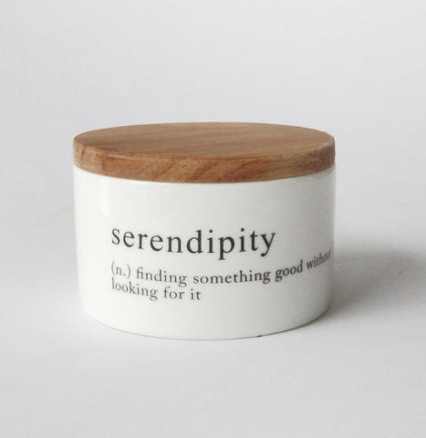 small white round jar with serendipity message